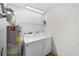 A laundry room equipped with a washer, dryer, water heater, and shelving at 3616 Ne 17Th Ln, Ocala, FL 34470