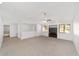 Spacious living room featuring a ceiling fan, neutral carpet, and bright natural light at 3616 Ne 17Th Ln, Ocala, FL 34470
