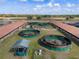 Equestrian facility showcasing multiple horse walkers and barns, set amidst green pastures under a bright sky at 4695 Ne 112Th Ln, Anthony, FL 32617