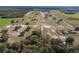 Sprawling horse farm showcasing paddocks, barns, a racetrack, and verdant landscape from an aerial perspective at 4695 Ne 112Th Ln, Anthony, FL 32617
