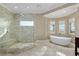 Luxurious bathroom featuring a glass shower and soaking tub with outdoor views at 4695 Ne 112Th Ln, Anthony, FL 32617