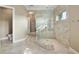 A well-lit bathroom featuring a glass shower with beige tiling and stone flooring, and neutral colored walls at 4695 Ne 112Th Ln, Anthony, FL 32617