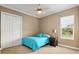 Relaxing bedroom with a plush blue bed, side table, and a window overlooking scenic pastures at 4695 Ne 112Th Ln, Anthony, FL 32617