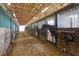 View of horse stalls inside the barn, each featuring wooden doors and metal accents at 4695 Ne 112Th Ln, Anthony, FL 32617