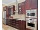 Gourmet kitchen featuring stainless steel appliances and rich, dark wood cabinetry at 4695 Ne 112Th Ln, Anthony, FL 32617