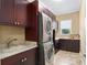 Well-organized laundry room featuring modern stacked washer and dryer, sink, granite countertops, and custom cabinets at 4695 Ne 112Th Ln, Anthony, FL 32617