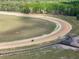 Aerial view of a horse race track with lush green surroundings and horses training at 4695 Ne 112Th Ln, Anthony, FL 32617