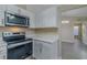 Modern kitchen with stainless steel appliances, quartz countertops, and white cabinetry, open to the living space at 5115 Nw 21St Loop, Ocala, FL 34482
