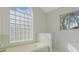 Bathroom featuring a tub under a glass block window, a second window, and tiled floors at 5347 Nw 20Th Pl, Ocala, FL 34482