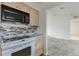 Clean kitchen features black microwave, tile backsplash and view into adjacent room at 5347 Nw 20Th Pl, Ocala, FL 34482