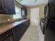 Functional kitchen with sleek black appliances, dark cabinets, and laminate countertops at 5520 Nw 57Th St, Ocala, FL 34482