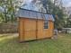 A wood-paneled storage shed in the backyard offering secure outdoor storage with a practical design at 5520 Nw 57Th St, Ocala, FL 34482