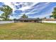 Spacious backyard featuring a screened-in pool, lawn area, and fenced perimeter under a partly cloudy blue sky at 6307 Se 8Th Ln, Ocala, FL 34472