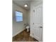 Cozy powder room featuring a white toilet, window, and door, offering functionality and a clean, simple design at 6307 Se 8Th Ln, Ocala, FL 34472