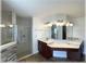 Bathroom showcasing a walk-in shower, dual vanity, stone accents, updated lighting, and tile flooring at 6307 Se 8Th Ln, Ocala, FL 34472