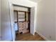 A wooden closet with shelving, drawers, and hanging areas is revealed by open, white, folding doors at 6307 Se 8Th Ln, Ocala, FL 34472