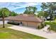 Home exterior with a long driveway, mature trees, and manicured lawn at 6307 Se 8Th Ln, Ocala, FL 34472