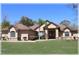 Inviting single-story home with a lush green lawn, mature trees, and a double-door entry, complete with manicured landscaping at 6307 Se 8Th Ln, Ocala, FL 34472