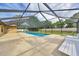 This backyard has a screened-in pool with a slide, surrounded by lush greenery, perfect for relaxation and recreation at 6307 Se 8Th Ln, Ocala, FL 34472