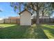 Exterior view of the backyard storage shed, nestled among mature trees at 7 Fir Drive Trce, Ocala, FL 34472