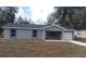 Charming single-story home with gray stucco, a modern roof, an attached garage, and a well-manicured lawn at 734 Nw 57Th Ave, Ocala, FL 34482
