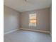 Cozy bedroom with neutral paint, bright window, and modern tile flooring at 75 Pine Crse, Ocala, FL 34472