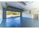 Large garage with epoxy floor, with an open garage door and view to the outdoors at 75 Pine Crse, Ocala, FL 34472