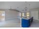 Open floor plan with modern kitchen featuring a blue island, pendant lighting, and white tile floors at 75 Pine Crse, Ocala, FL 34472