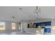 Open-concept kitchen and living area with vaulted ceilings, modern lighting, and a blue kitchen island at 75 Pine Crse, Ocala, FL 34472