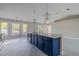 Bright kitchen featuring a blue island with a breakfast bar, stainless steel appliances, and modern pendant lights at 75 Pine Crse, Ocala, FL 34472
