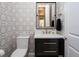Stylish powder room with patterned wallpaper, a modern vanity, and elegant fixtures at 7635 Nw 33Rd Pl, Ocala, FL 34482
