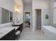 Elegant bathroom with double vanity, soaking tub, and open layout to the main bedroom at 7635 Nw 33Rd Pl, Ocala, FL 34482