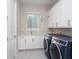 Well-equipped laundry room with front-load washer and dryer, ample counter space, and plenty of storage at 7635 Nw 33Rd Pl, Ocala, FL 34482