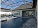 Relaxing screened pool area with a jacuzzi, sun loungers, and view of the lush landscaping and exterior at 7635 Nw 33Rd Pl, Ocala, FL 34482