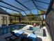 Stunning screened pool area with a jacuzzi, loungers, and view of the lush landscaping and greenery at 7635 Nw 33Rd Pl, Ocala, FL 34482