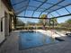 Sparkling screened pool with a jacuzzi, sun loungers, and a beautiful view of the lush landscaping and greenery at 7635 Nw 33Rd Pl, Ocala, FL 34482
