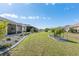 Landscaped backyard with a large lawn, decorative trees, and screened patio offers outdoor enjoyment at 7698 Sw 85Th Cir, Ocala, FL 34481