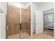 Shower features glass doors, tan tile, and a built-in shelf in this bathroom at 7698 Sw 85Th Cir, Ocala, FL 34481