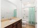 Bathroom with large mirror, single sink vanity, and shower with blue curtain at 7698 Sw 85Th Cir, Ocala, FL 34481