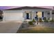 Charming single-story home featuring a well-manicured lawn, an attached garage, and a welcoming front porch with rocking chairs at 7698 Sw 85Th Cir, Ocala, FL 34481