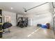Well lit garage with an open floor plan, featuring a golf cart, large refrigerator, and ample storage shelving at 7698 Sw 85Th Cir, Ocala, FL 34481