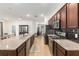 Open kitchen layout featuring an island with a sink, dark wood cabinets, and stainless steel appliances at 7698 Sw 85Th Cir, Ocala, FL 34481