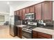 Well-equipped kitchen with granite countertops, stainless steel appliances, and dark cabinetry at 7698 Sw 85Th Cir, Ocala, FL 34481