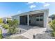 Exterior rear view showcasing the screened lanai, stone pavers, and beautiful landscaping in the backyard at 7698 Sw 85Th Cir, Ocala, FL 34481