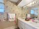A spacious bathroom featuring dual sinks and wallpaper with a floral pattern at 7955 Sw 62Nd Ct, Ocala, FL 34476