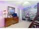 A bedroom with a mural on the wall, and a ceiling fan with lights at 7955 Sw 62Nd Ct, Ocala, FL 34476