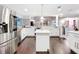 Bright kitchen boasts stainless appliances, mosaic backsplash, and large island with dark, hardwood floors at 7955 Sw 62Nd Ct, Ocala, FL 34476