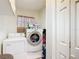 Laundry room with a washer and dryer and a floral curtain over the window at 7955 Sw 62Nd Ct, Ocala, FL 34476