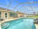 Sparkling screened-in pool with ample patio space for relaxation and entertaining on a sunny day at 7955 Sw 62Nd Ct, Ocala, FL 34476