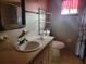 Functional bathroom with a vanity, toilet, mirror, and shelving for storage, offering a practical space at 8344 Sw 107Th Pl, Ocala, FL 34481
